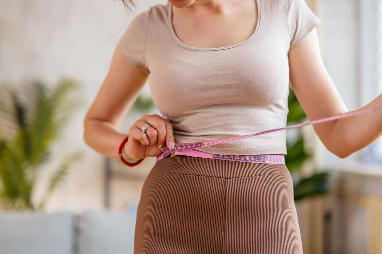 Young Woman Measuring Her Waist after weight loss