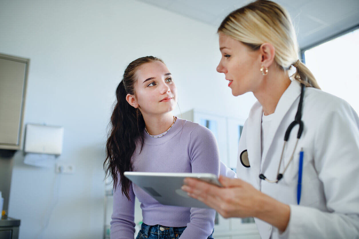 adolescent medicine physician talking to teen girl